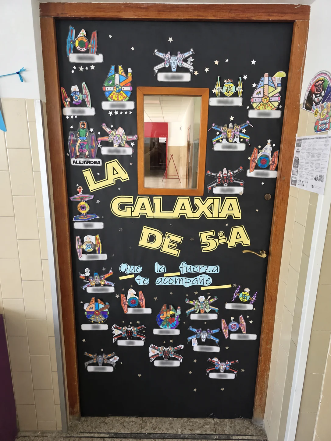 Puerta de clase terminada con una galaxia de naves espaciales creadas por el alumnado