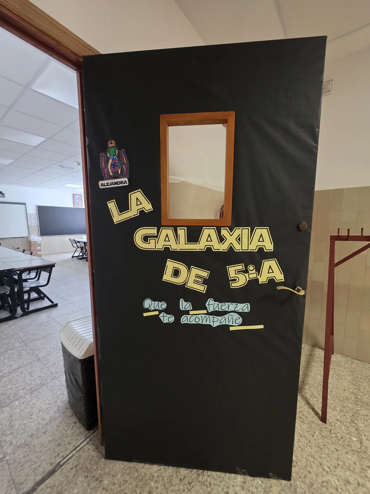 Puerta negra del aula con el rótulo La galaxia de 5.º A y la frase Que la fuerza te acompañe