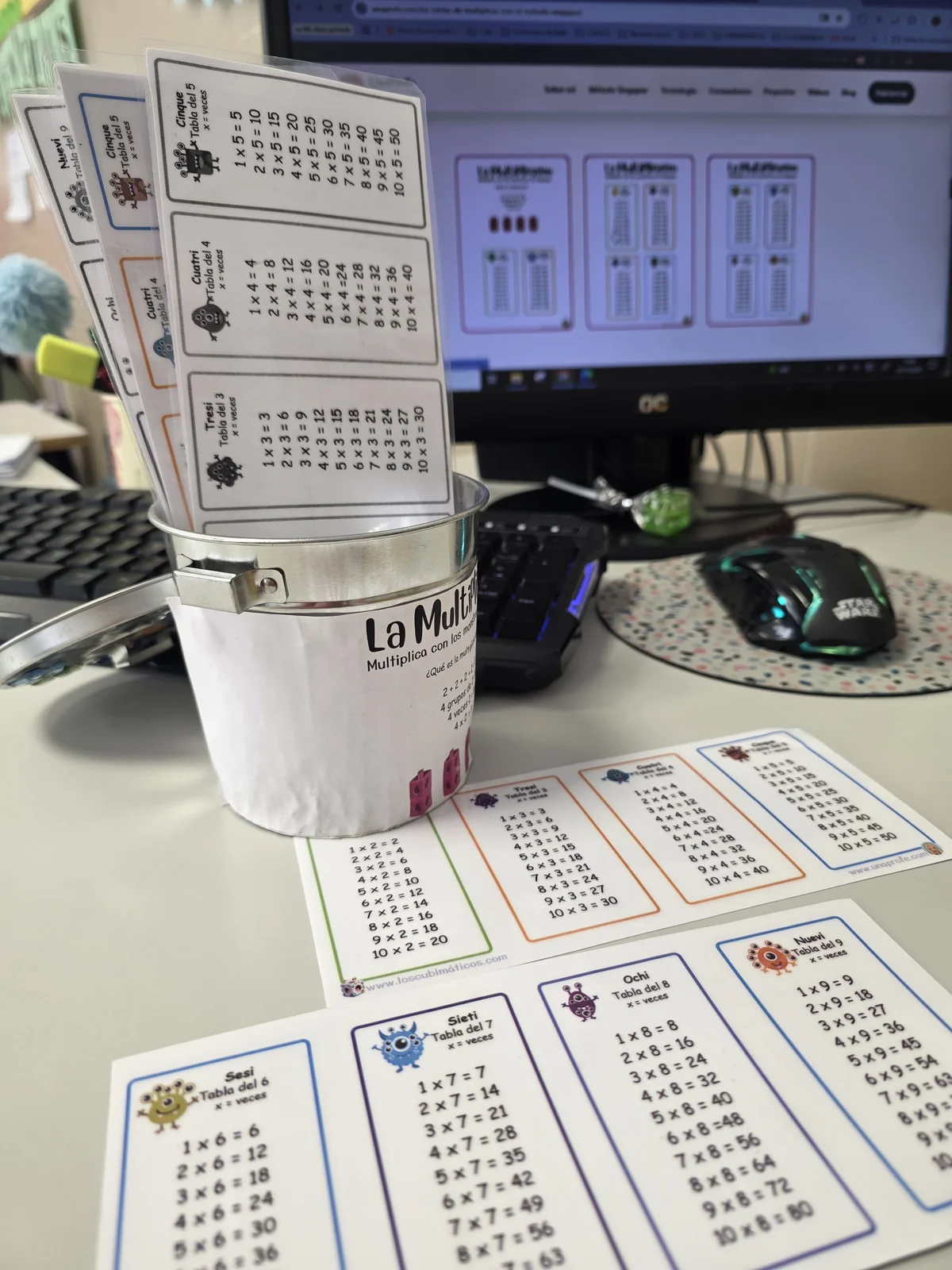 Bote con las tarjetas de las tablas de multiplicar plastificadas en mi mesa de clase